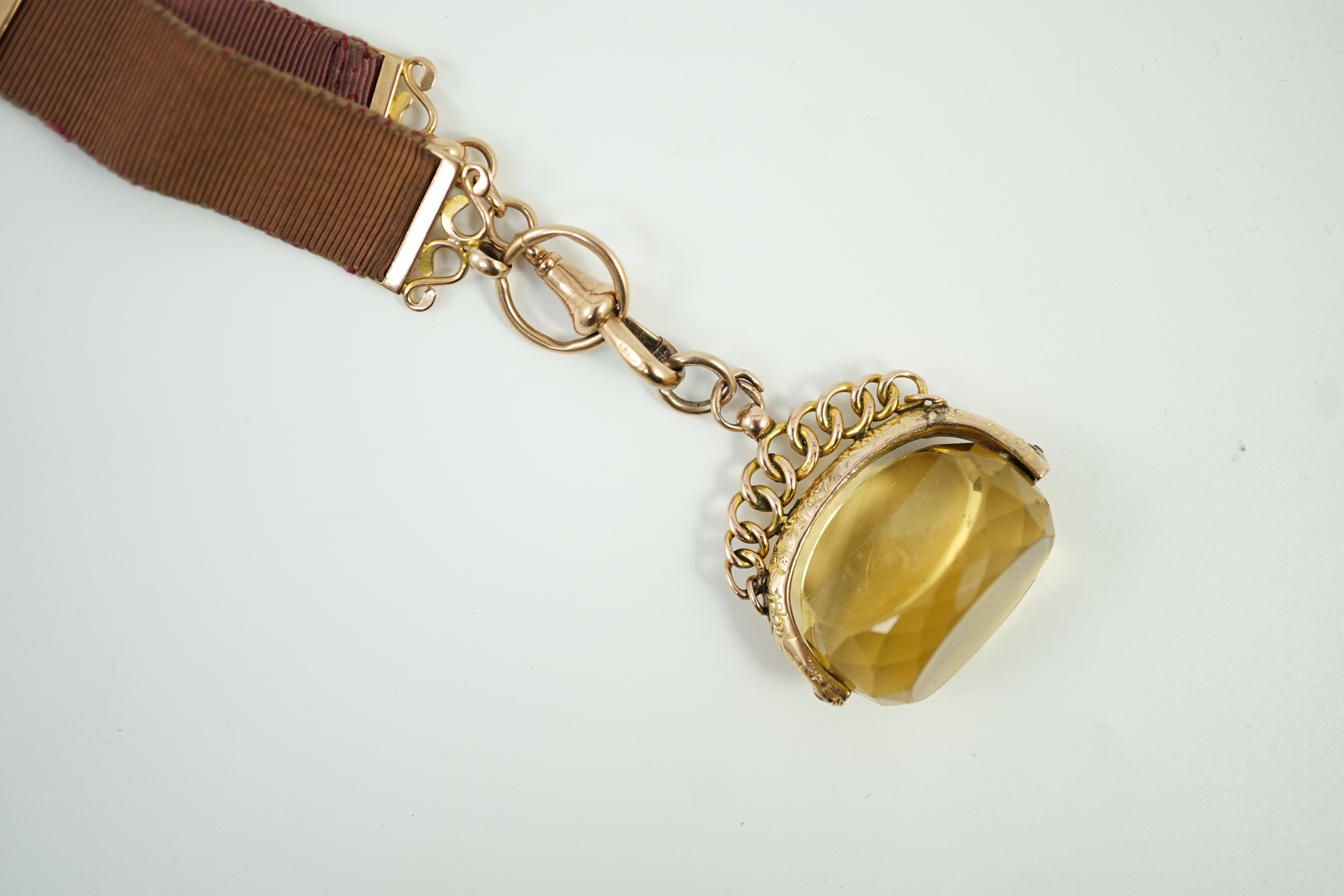 A late Victorian yellow metal and citrine set spinning fob, width 37mm, on a yellow metal mounted suspension sash, gross weight 31.6 grams.